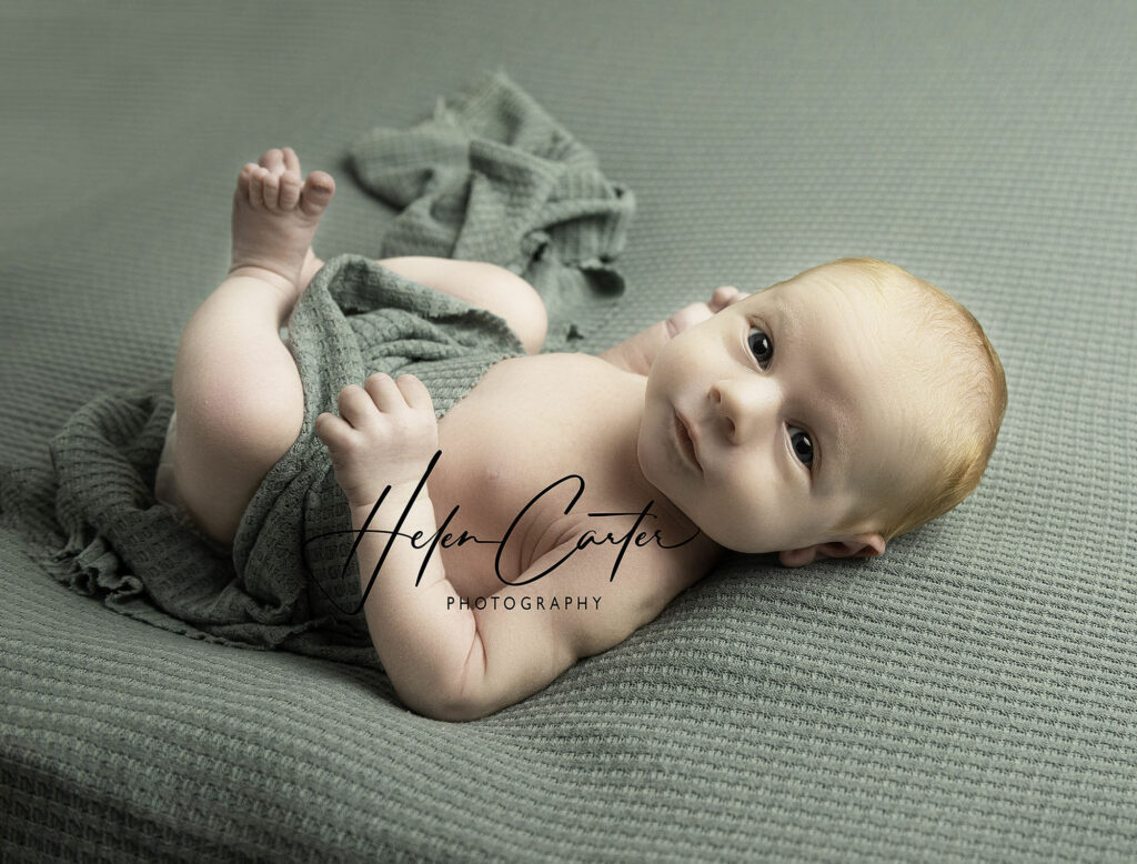 Newborn baby looking around during photoshoot with Helen Carter